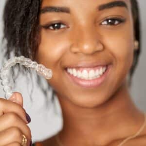 girl holding up her invisalign